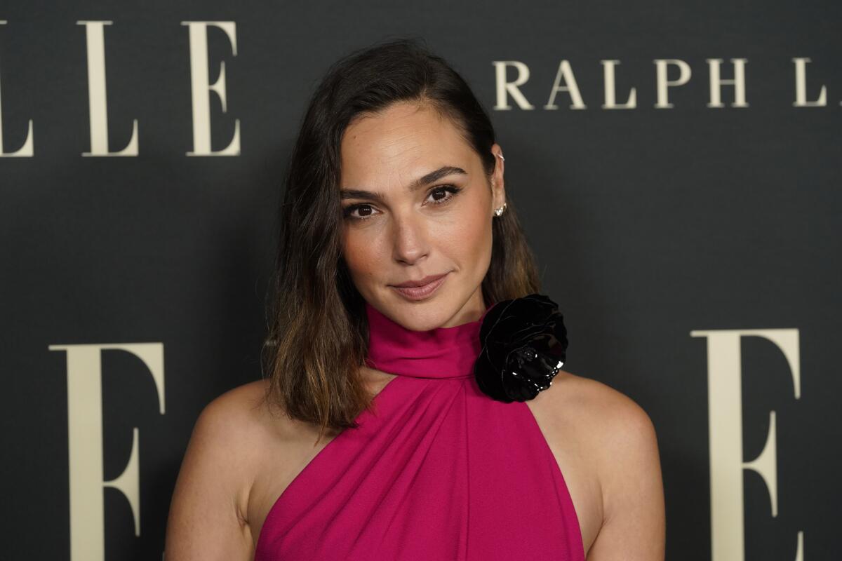 Gal Gadot looks straight into the camera in a pink halter dress