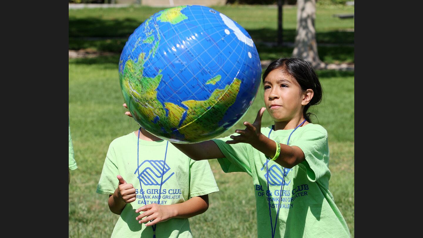 Alani Ramirez, 8, of Burbank, catches a big inflatable globe, about to tell if her right thumb landed on land or water, at Robert E Lundigan Park where Nestlé and the Boys and Girls Club of Burbank work together to teach young children about conservation on Thursday, August 10, 2017. Nationwide, 150 events were scheduled.