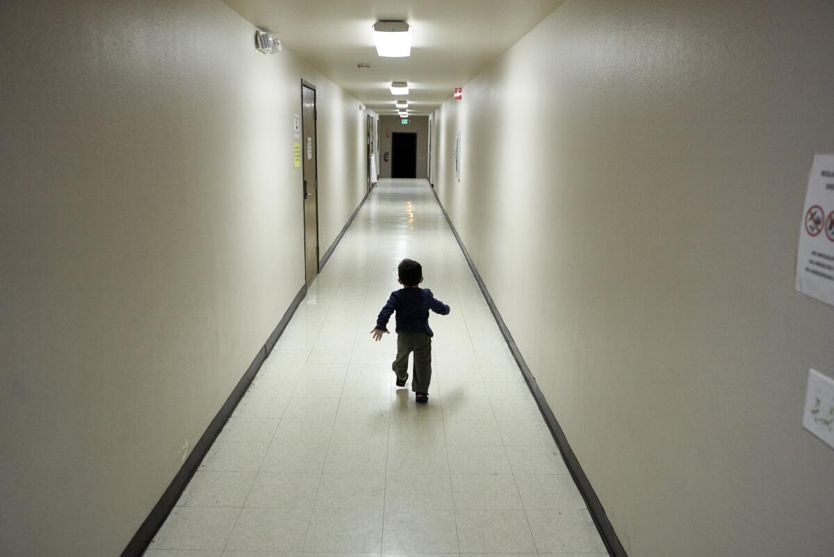 FILE - In this Dec. 11, 2018 file photo, an asylum-seeking boy from Central America runs down a hallway after arriving from an immigration detention center to a shelter in San Diego. The federal government may house unaccompanied migrant children on a California Army National Guard base in central California, officials said. The Pentagon on Friday, April 2, 2021, approved the use of Camp Roberts to temporarily house children traveling alone, according to a defense official. (AP Photo/Gregory Bull, File)