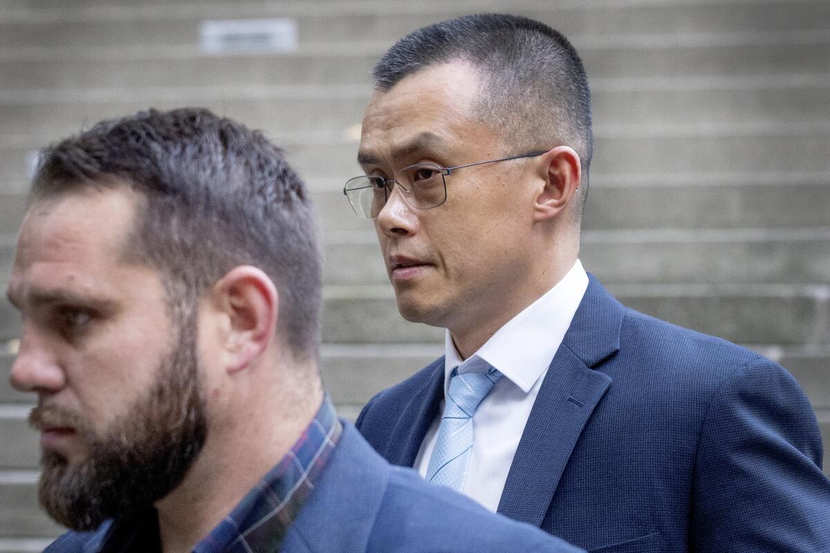 Binance founder and CEO Changpeng Zhao, right, leaves federal court