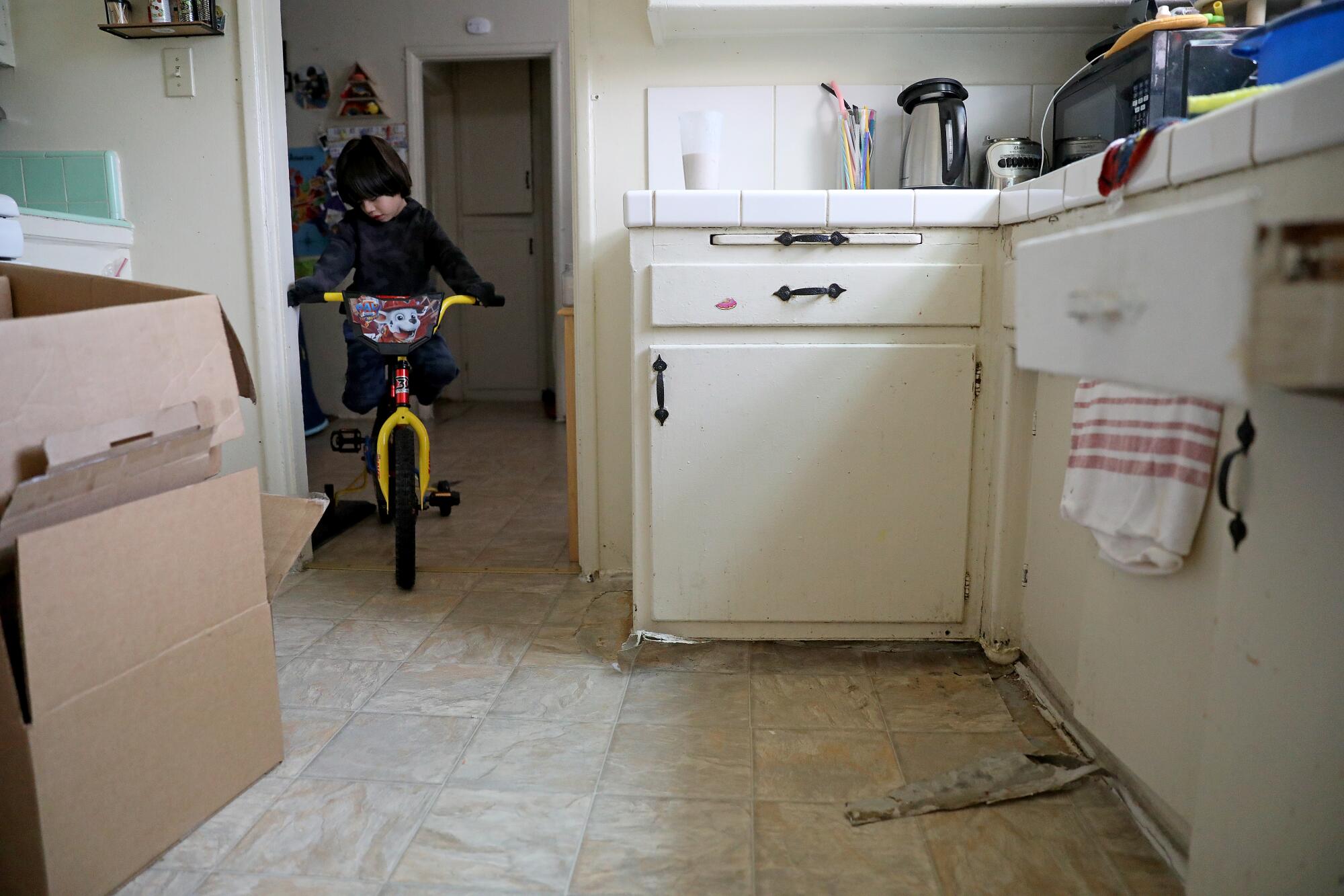 Liam Ponce plays on a cracked kitchen floor   at the Chesapeake Apartments.