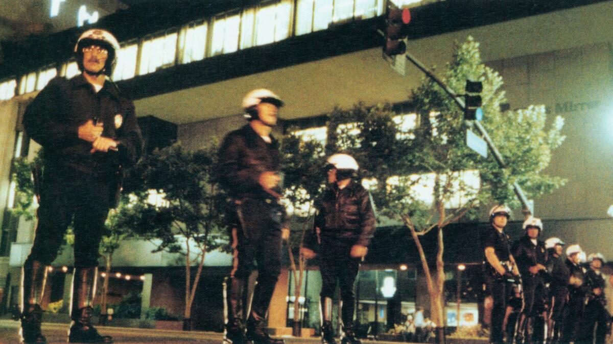 April 29, 1992: Los Angeles Police officers form a line across 1st Street in front of the Los Angeles Times building after rioters smashed windows.