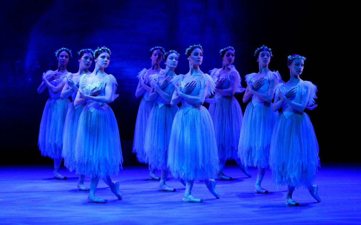 Three rows of three ballerinas dancing on stage.