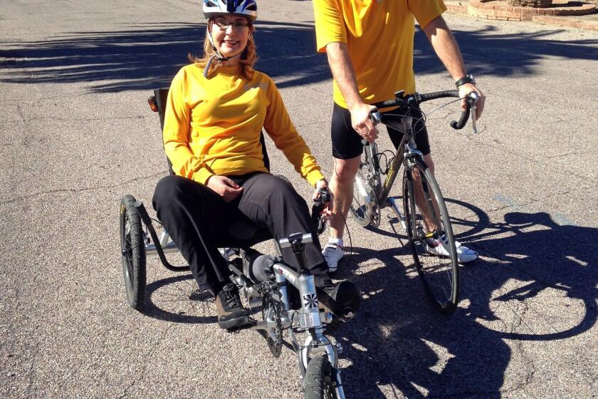 Former congresswoman Gabrielle Giffords and her husband, Mark Kelly, pause while training for a 40-mile charity ride called El Tour de Tucson, held Saturday.