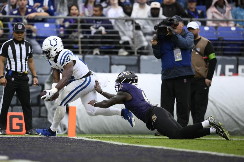 Indianapolis Colts running back Zack Moss (21) scores a touchdown against Baltimore Ravens' Patrick Queen during the first half of an NFL football game, Sunday, Sept. 24, 2023, in Baltimore. (AP Photo/Nick Wass)