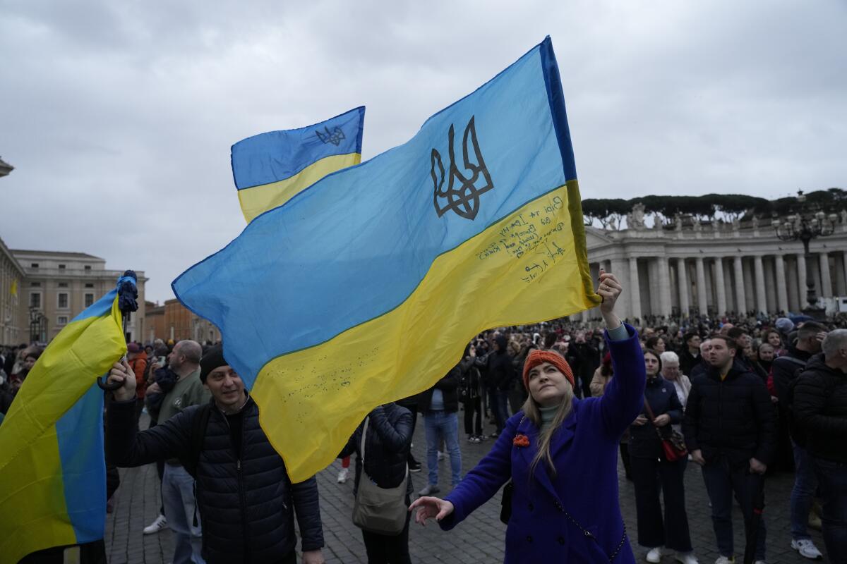 People wave Ukrainian flags.