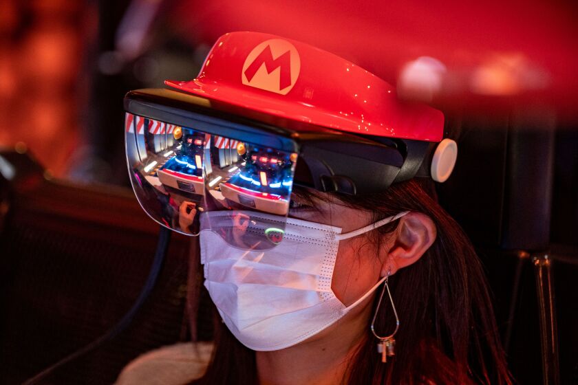 In this picture taken on March 17, 2021, a fan of Universal Studios Japan wears themed augmented reality goggles on the "Mario Kart" ride during a media preview of the theme park at Universal Studios Japan in Osaka. (Photo by Philip FONG / AFP) (Photo by PHILIP FONG/AFP via Getty Images)