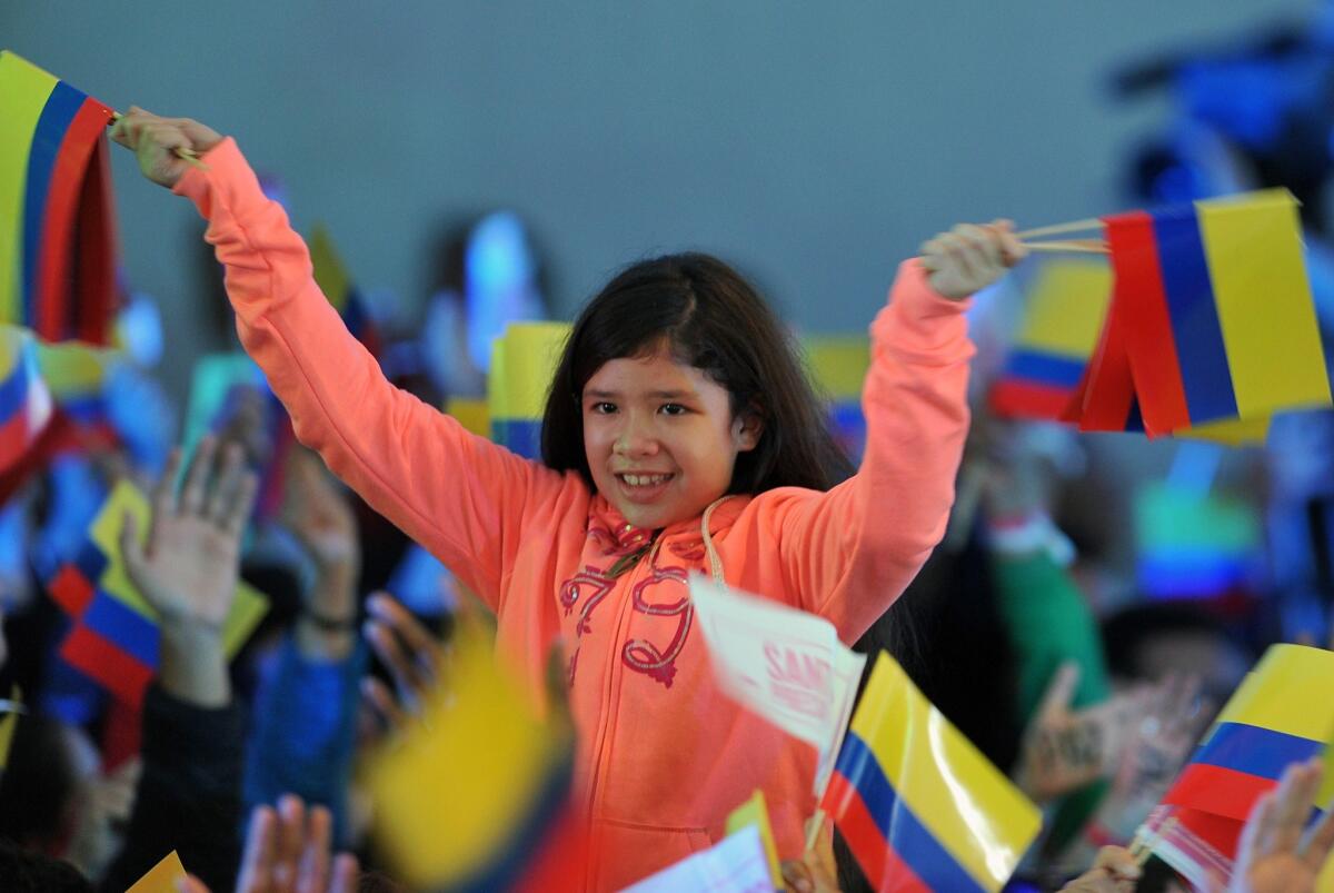 A girl waves Colombian national flags as supporters of President Juan Manuel Santos celebrate after results indicated that he won Sunday's runoff election.