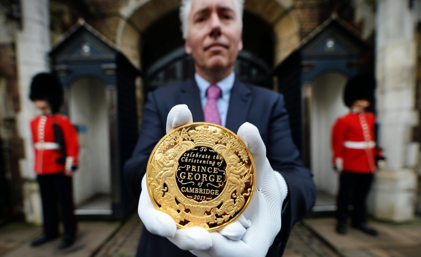 Gordon Summer, Chief engraver for the Royal Mint, holds a commemorative gold coin to celebrate the christening of Prince George outside St James' Palace in London.