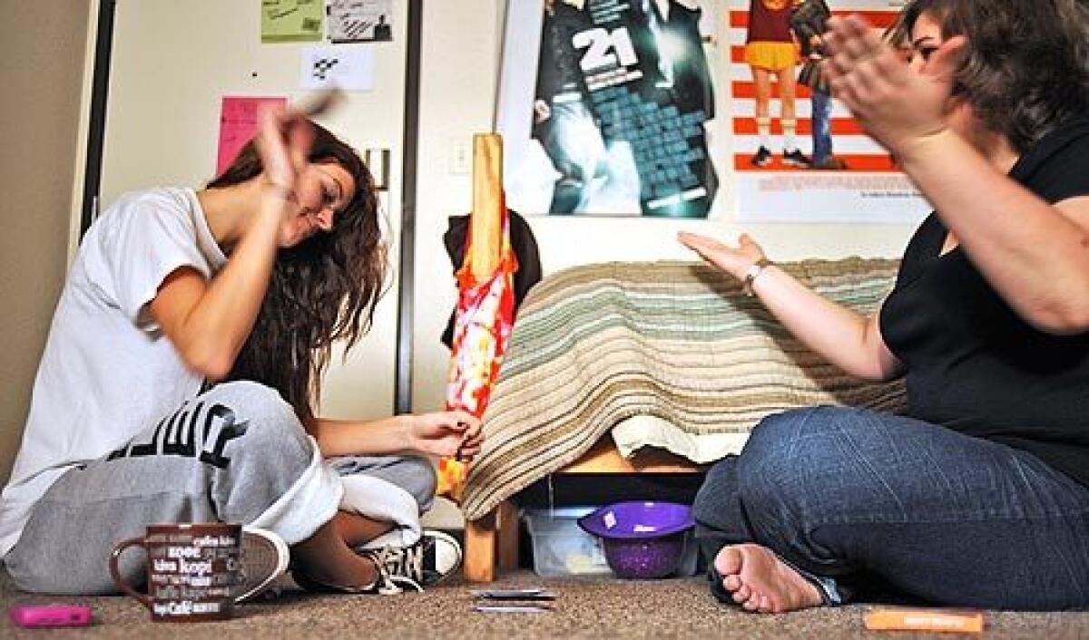 Meg Miller of Massachusetts, left, throws her cards down after Samantha Roper of Idaho wins a game of Crazy 8's in Samantha's dorm room at Chapman University in Fullerton. The two friends will spend Thanksgiving on campus and will have microwave food from Wal-Mart for Thanksgiving dinner.