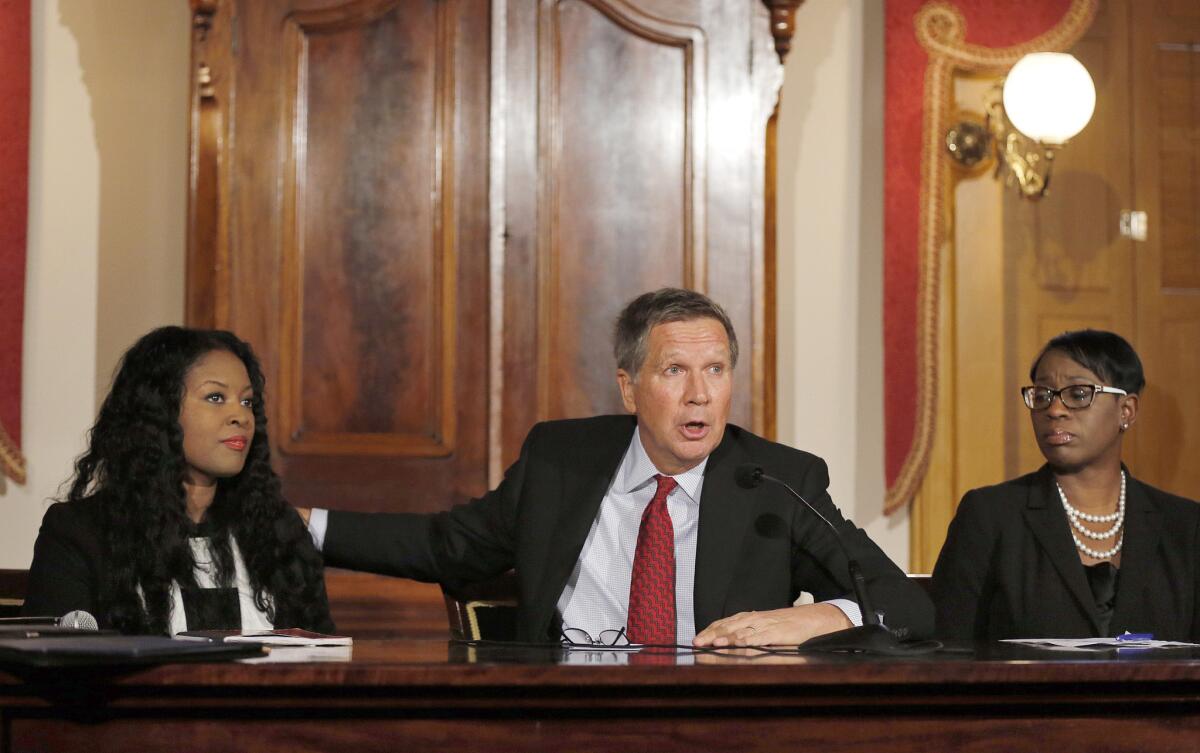 Flanked by Rep. Alicia Reece, left, and Sen. Nina Turner, Ohio Gov. John Kasich announces a new task force to improve community-police relations.