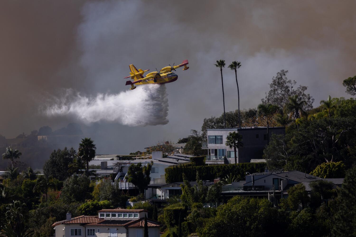 Pacific Palisades, CA - January 07: A Super Scooper drops ocean water on a hillside as the Palisades fire rages on Tuesday, Jan. 7, 2025 in Pacific Palisades, CA. (Brian van der Brug / Los Angeles Times)