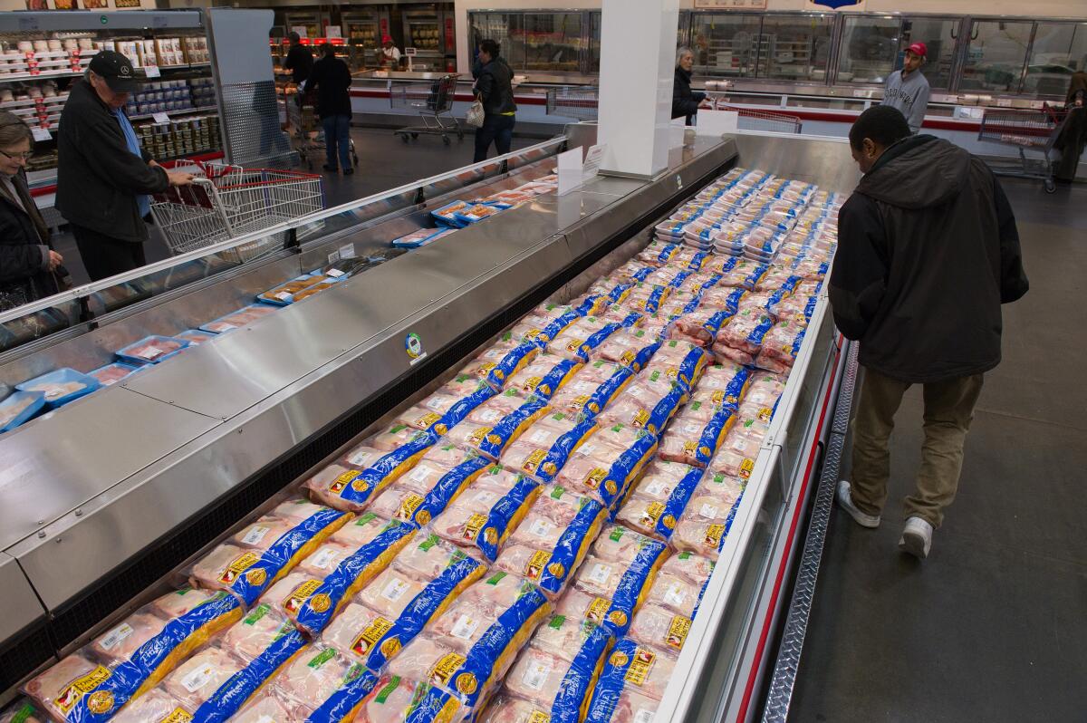 Customers browse Foster Farms chicken displayed for sale at a Costco store
