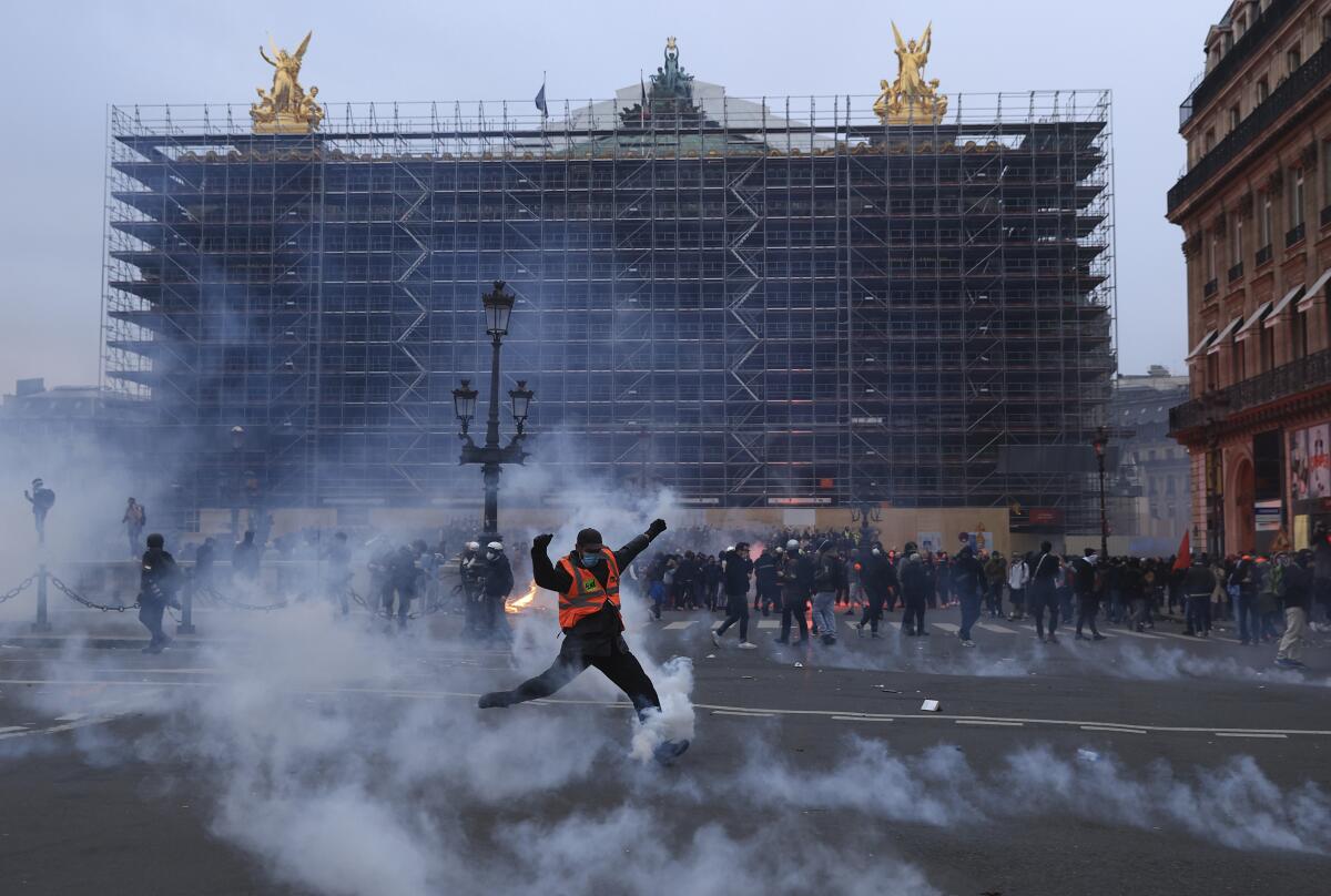 Protester kicking a tear gas canister in front of Paris opera house