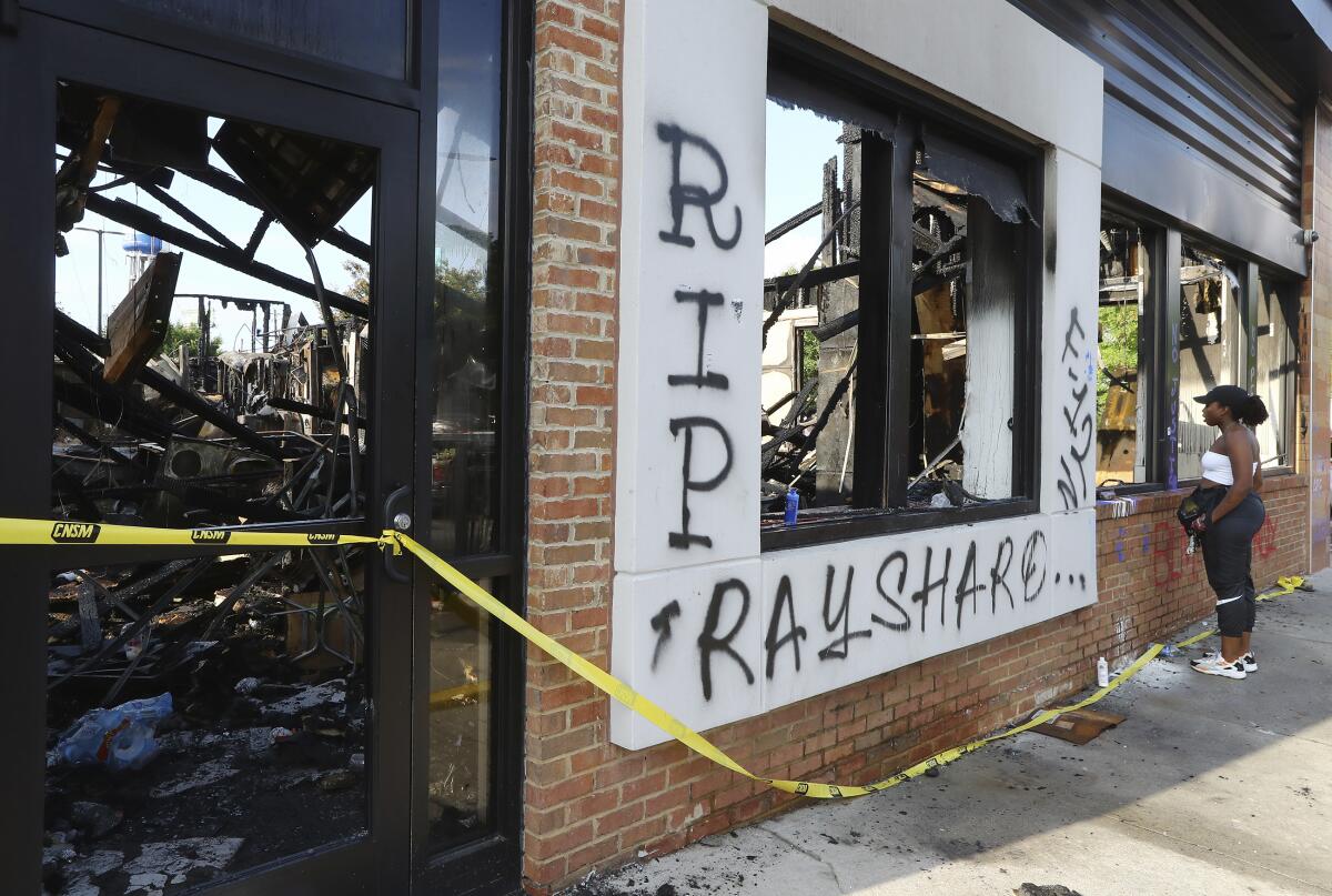 A woman looks at the interior of the burned Wendy's restaurant in Atlanta.