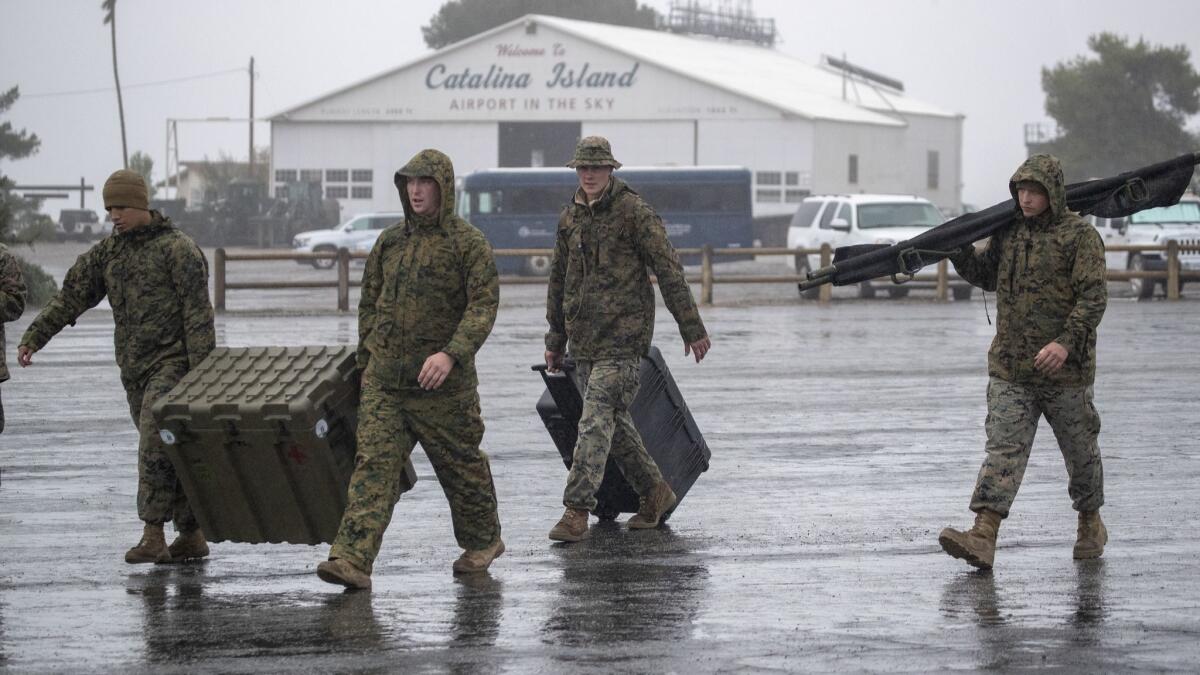 Marines from the 3rd Marine Aircraft Wing carry supplies to tents at Airport in the Sky on Santa Catalina Island.