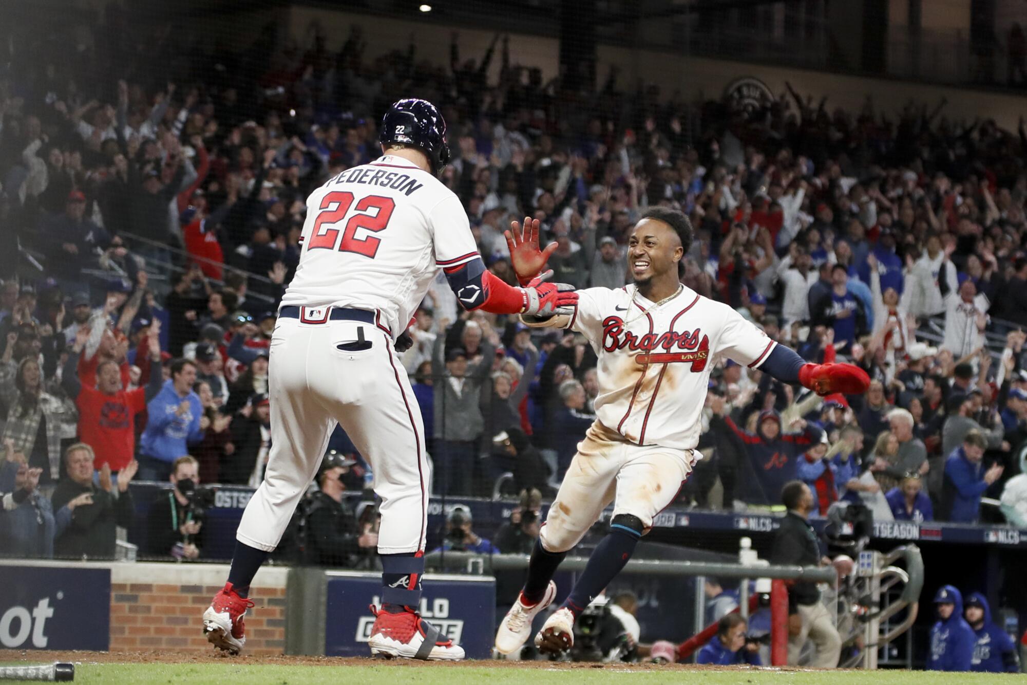 Atlanta Braves' Ozzie Albies, right, celebrates with Joc Pederson after scoring the game-winning run during the ninth inning.