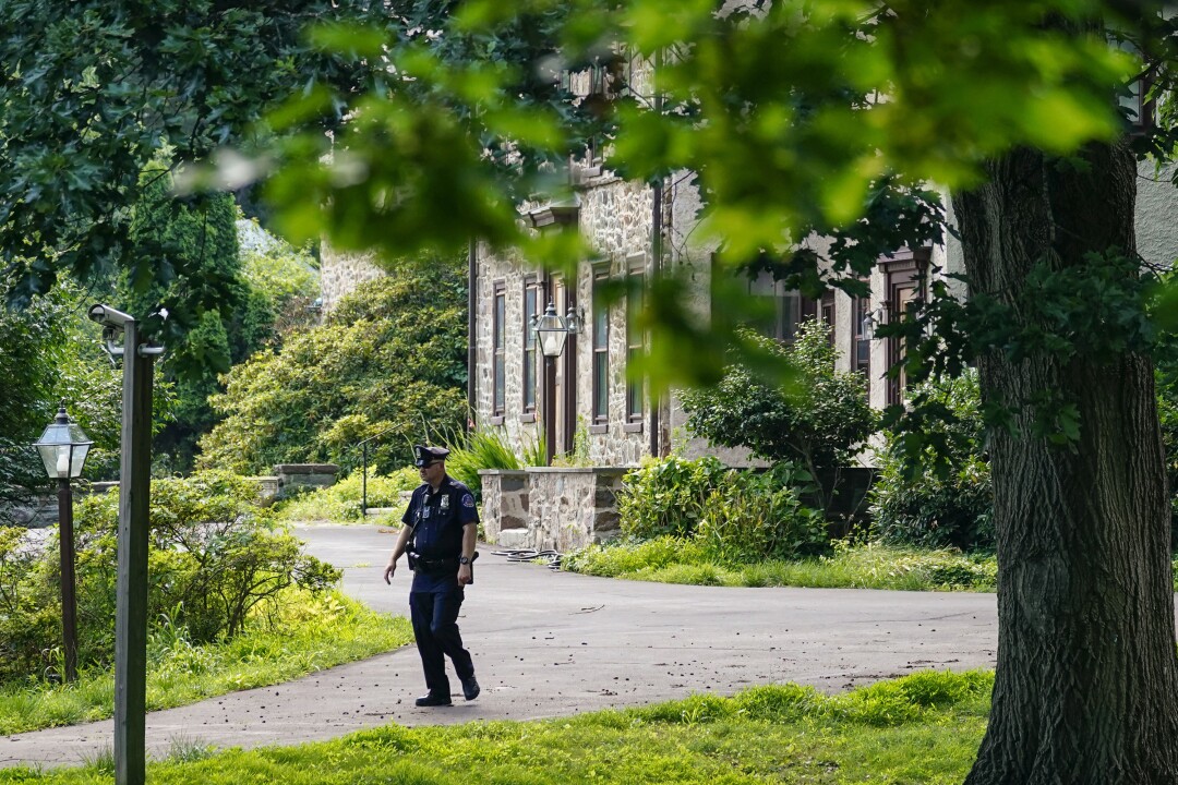 A policeman patrols past the home of Bill Cosby in Elkins Park, Pa.