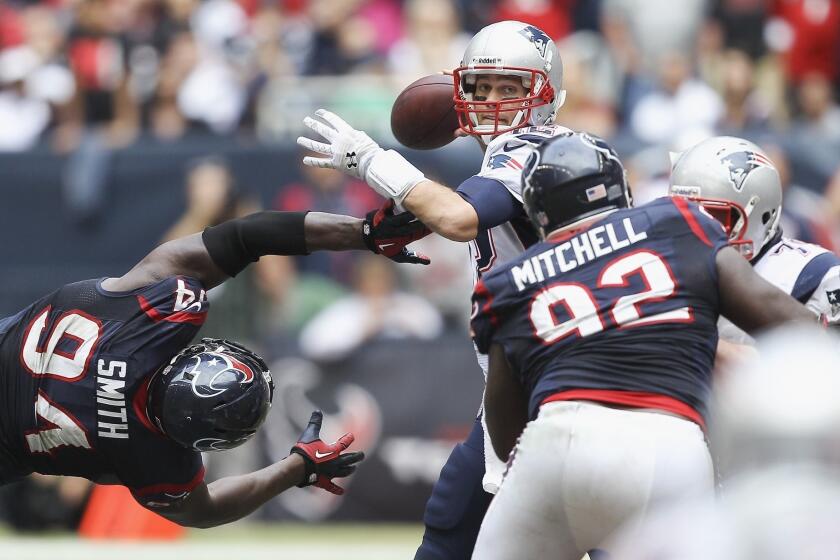 Houston's Antonio Smith and Earl Mitchell try to get to New England quarterback Tom Brady at Reliant Stadium on Sunday.