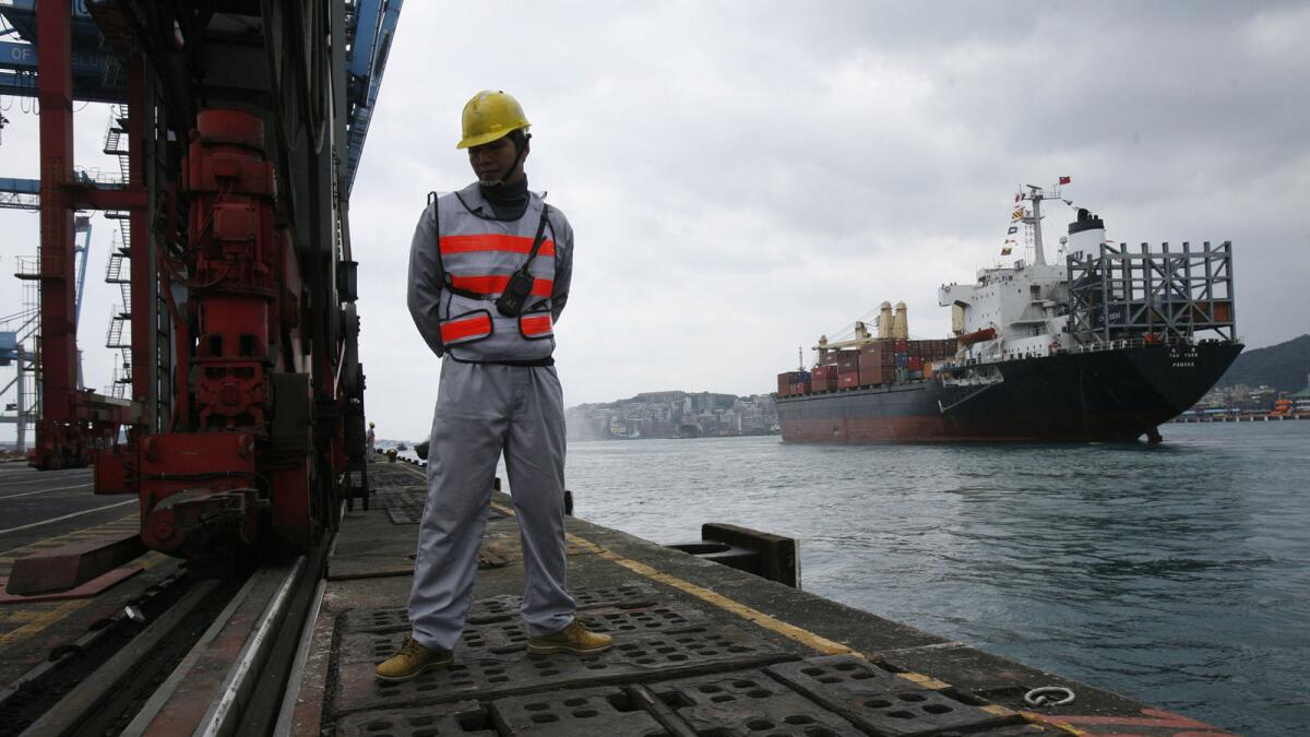 A dock worker sees off a cargo ship leaving the northern Taiwan harbor of Keelung on Dec. 15, 2008.
