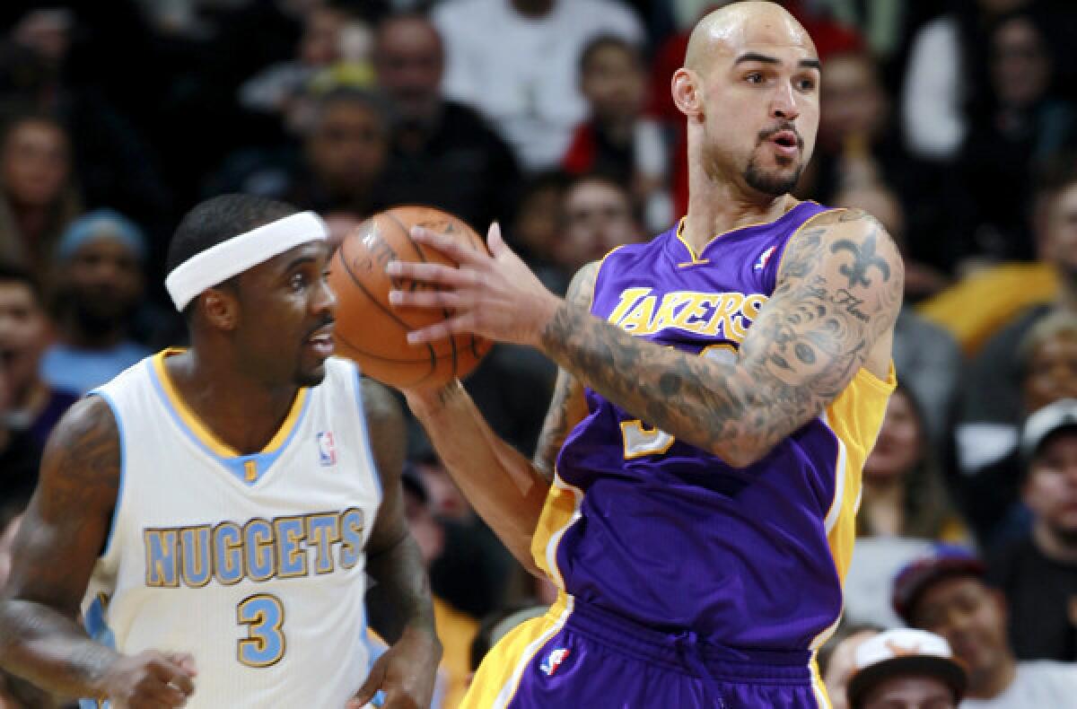 Lakers center Robert Sacre looks to make an outlet pass as Nuggets point guard Ty Lawson heads back on defense in the first half of their game Friday night in Denver.