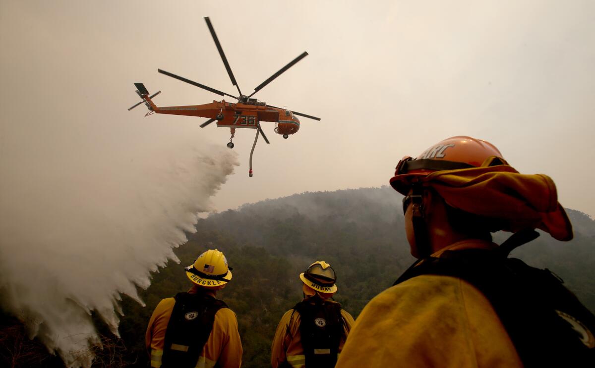 A helicopter drops water on the Alamo fire near Santa Maria on Saturday.