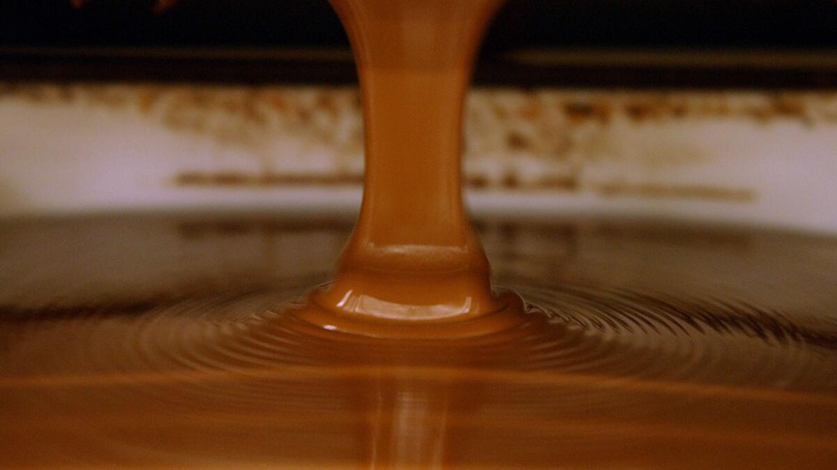 Chocolate is poured into molds at a factory. A new study finds that subjecting chocolate to an electric field could allow manufacturers to reduce the fat content by up to 20%.
