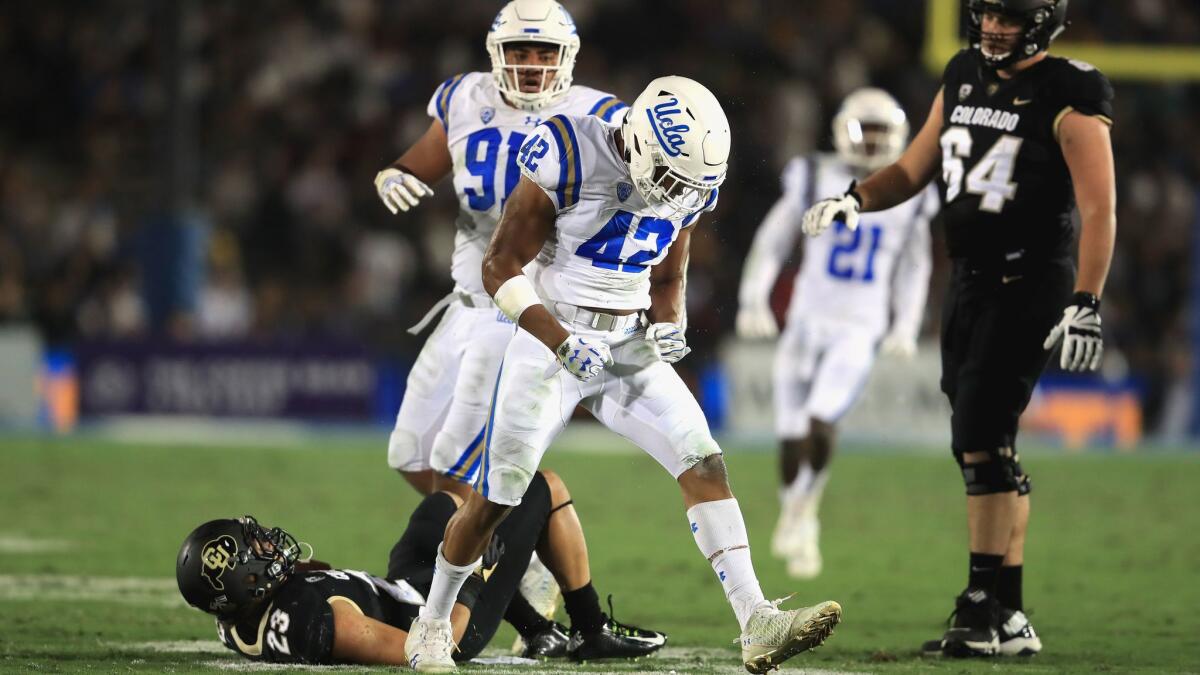 UCLA's Kenny Young (42) and Jacob Tuioti-Mariner celebrate a tackle of Colorado's Phillip Lindsay on Sept. 30.