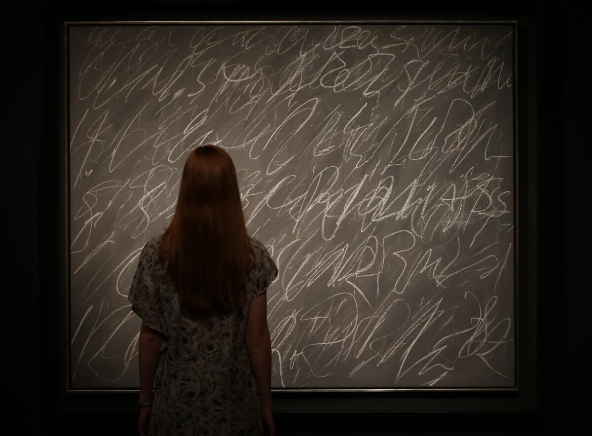A Christie's employee looks at an untitled work by Cy Twombly in London last week. On Wednesday, the piece sold for about $30 million.