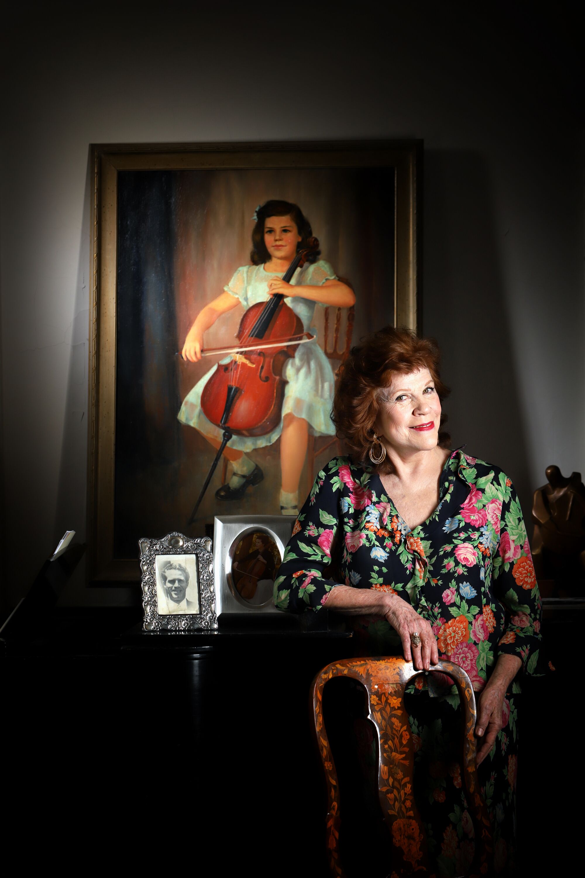 Christine Walevska stands in her Manhattan home alongside a portrait of herself as a child with her Bernardel cello.