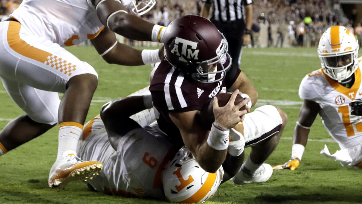 Texas A&M quarterback Trevor Knight dives over Tennessee defensive end Derek Barnett (9) to score a touchdown during overtime of their game Saturday.