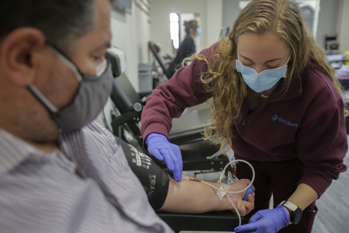 Harry Rosengrant gives blood at the Liberty Station Donor Center with the help of donor technician Alyssa Stromsland.. 