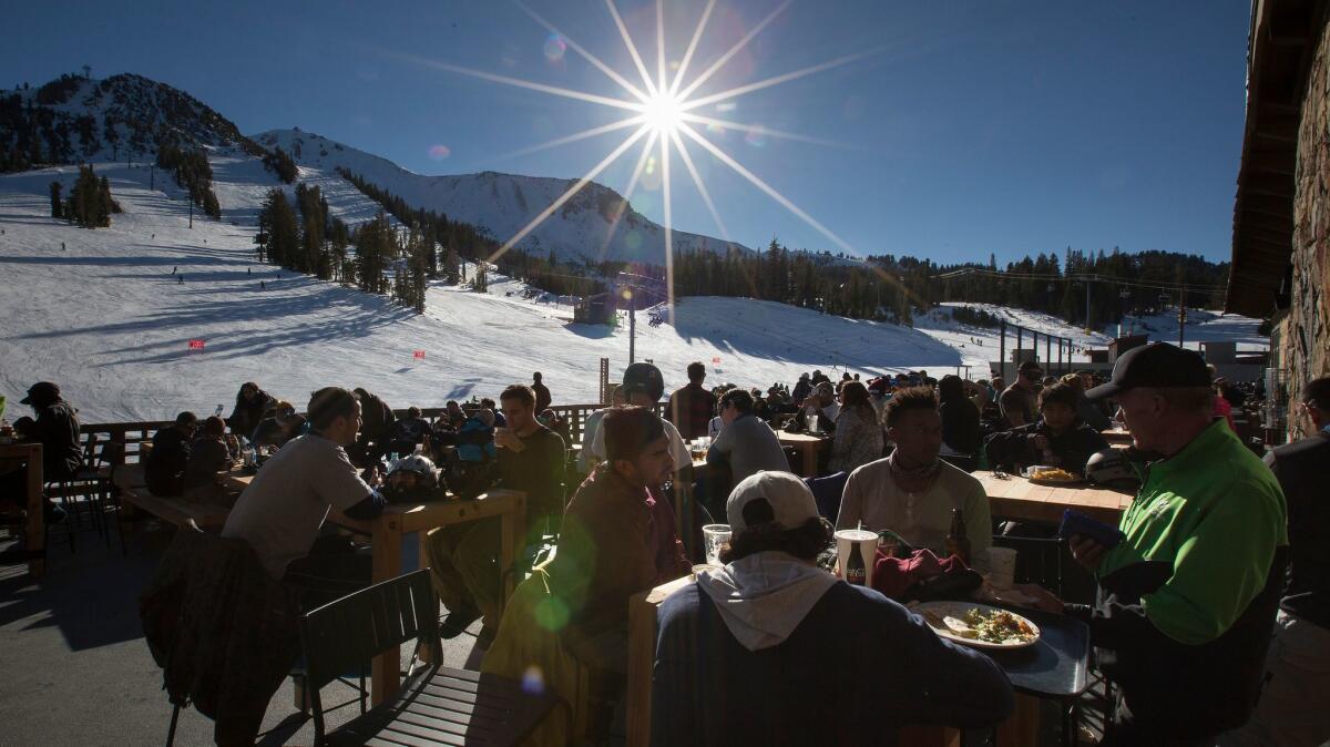 Skiers and snowboarders enjoy food and beverages at Tusks Bar overlooking the slopes at Mammoth Mountain. The resort and others owned by Mammoth Resorts are being bought by a Colorado partnership.