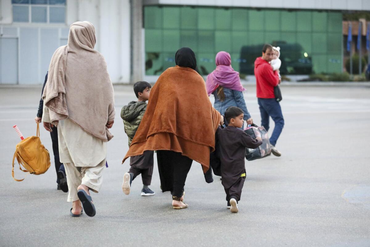 Afghans evacuated by U.S. forces arrive at the Pristina International Airport in Kosovo on Oct. 16. 