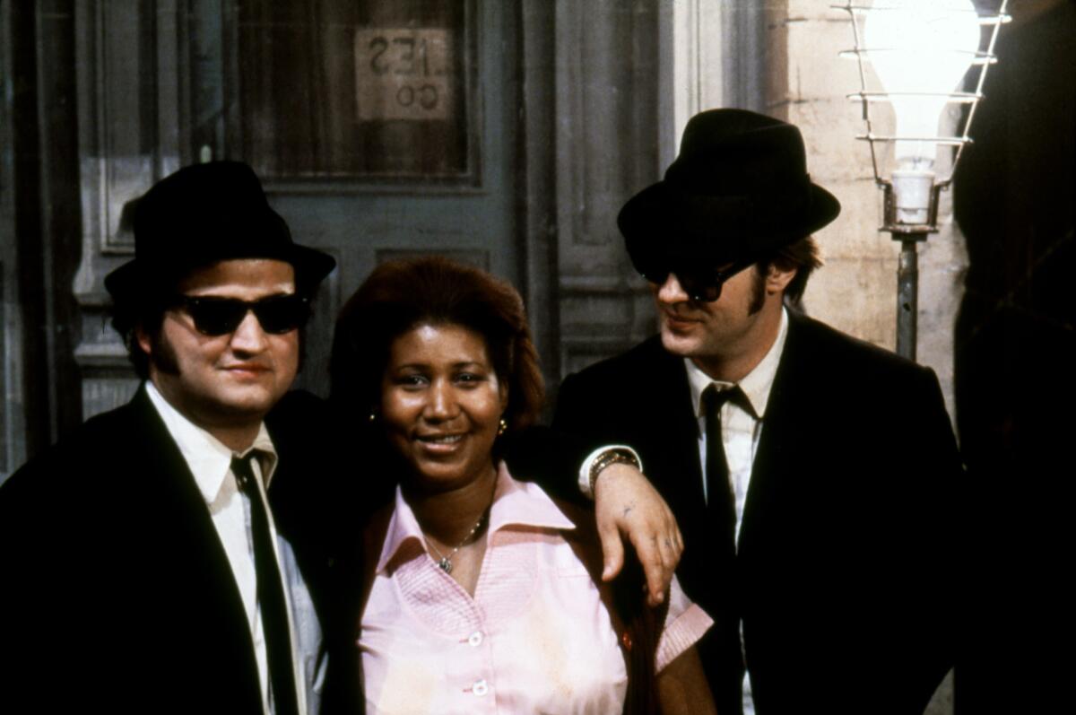 Aretha Franklin is flanked by actors John Belushi, left, and Dan Aykroyd on the set of the 1980 film "The Blues Brothers."