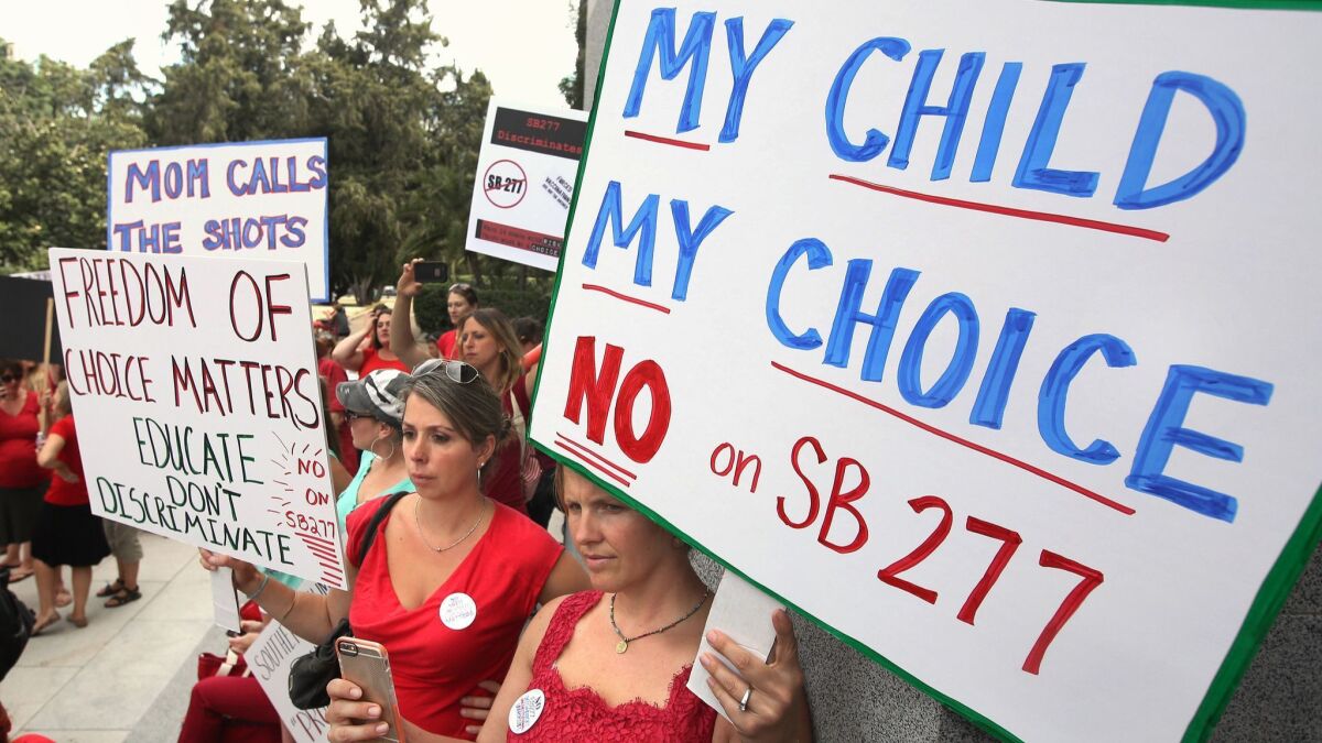 FILE - In this June 9, 2015, file photo, Karman Willmer, left, and Shelby Messenger rally against SB 277, a California measure requiring schoolchildren to get vaccinated, outside the Capitol in Sacramento, Calif. California's Assembly on Thursday, June 25, 2015, approved a hotly contested bill requiring that nearly all public schoolchildren be vaccinated, clearing one of its last major legislative obstacles before the measure heads to the desk of Gov. Jerry Brown. The bill aims to increase immunization rates after a measles outbreak linked to Disneyland in December sickened over 100 people in the U.S. and Mexico. (AP Photo/Rich Pedroncelli, File) ORG XMIT: LA113