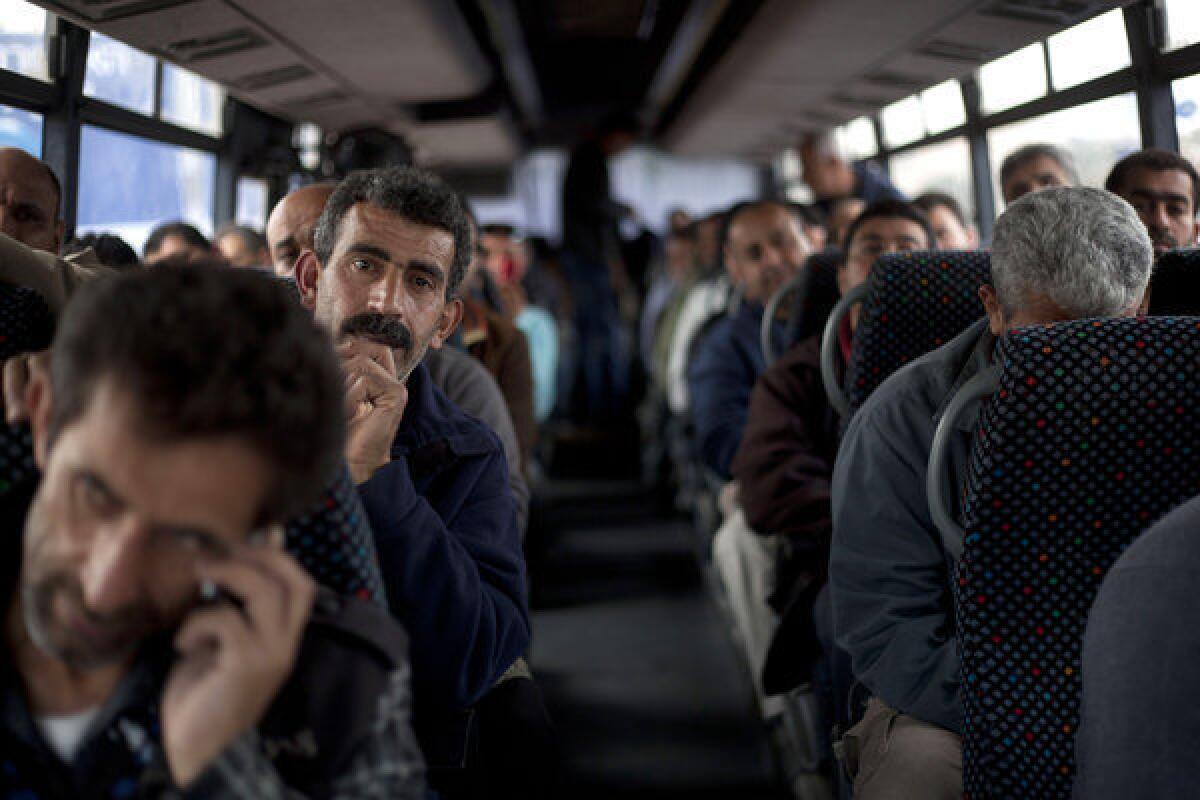 Palestinian laborers ride a bus to the West Bank on Monday after working at jobs inside Israel. The Israeli government calls its move to launch a pair of bus lines specifically for Palestinians a goodwill gesture but critics say it is racist.