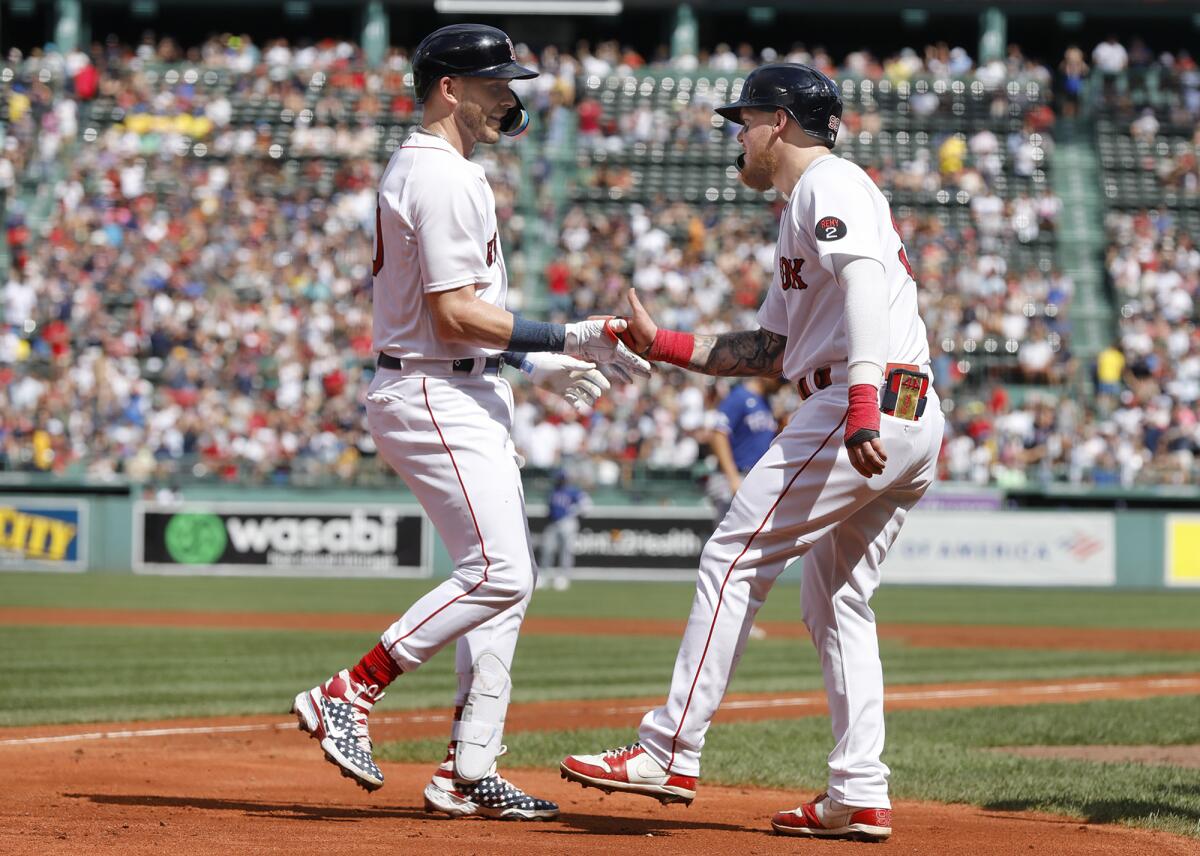 Boston Red Sox' Trevor Story, left, is congratulated by teammate Alex Verdugo, right, at home plate after hitting a three-run home run off Texas Rangers pitcher Dane Dunning during the first inning of a baseball game at Fenway Park, Sunday Sept. 4, 2022, in Boston.(AP Photo/Paul Connors)