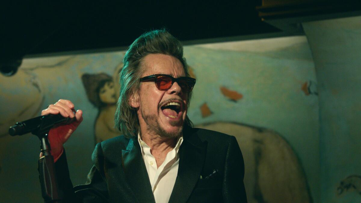 David Johansen laughs on stage with a microphone in a scene from "Personality Crisis: One Night Only."
