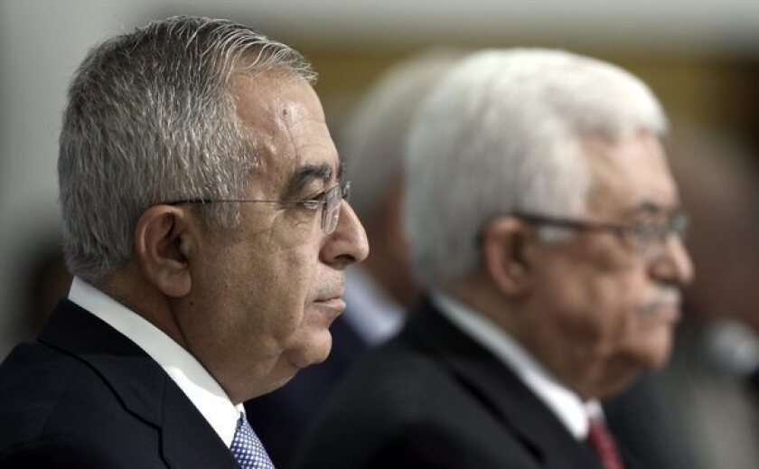 Palestinian Authority Prime Minister Salam Fayyad, left, on May 16, 2012 with President Mahmoud Abbas during the swearing in of a new Cabinet in the West Bank town of Ramallah.