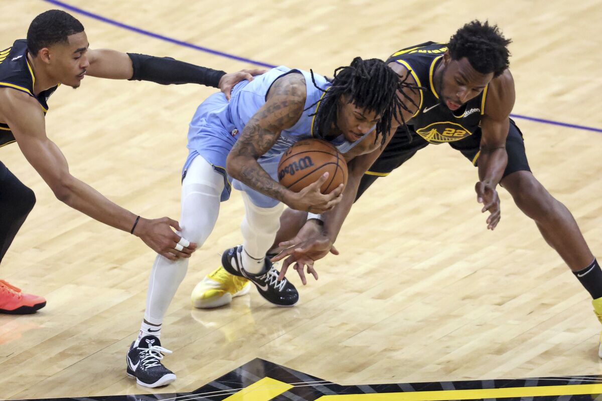Golden State Warriors' Jordan Poole, left, and Andrew Wiggins defends against Memphis Grizzlies' Ja Morant during the fourth quarter in Game 3 of NBA basketball playoffs Western Conference semifinal in San Francisco on Saturday, May 7, 2022. (Scott Strazzante/San Francisco Chronicle via AP)