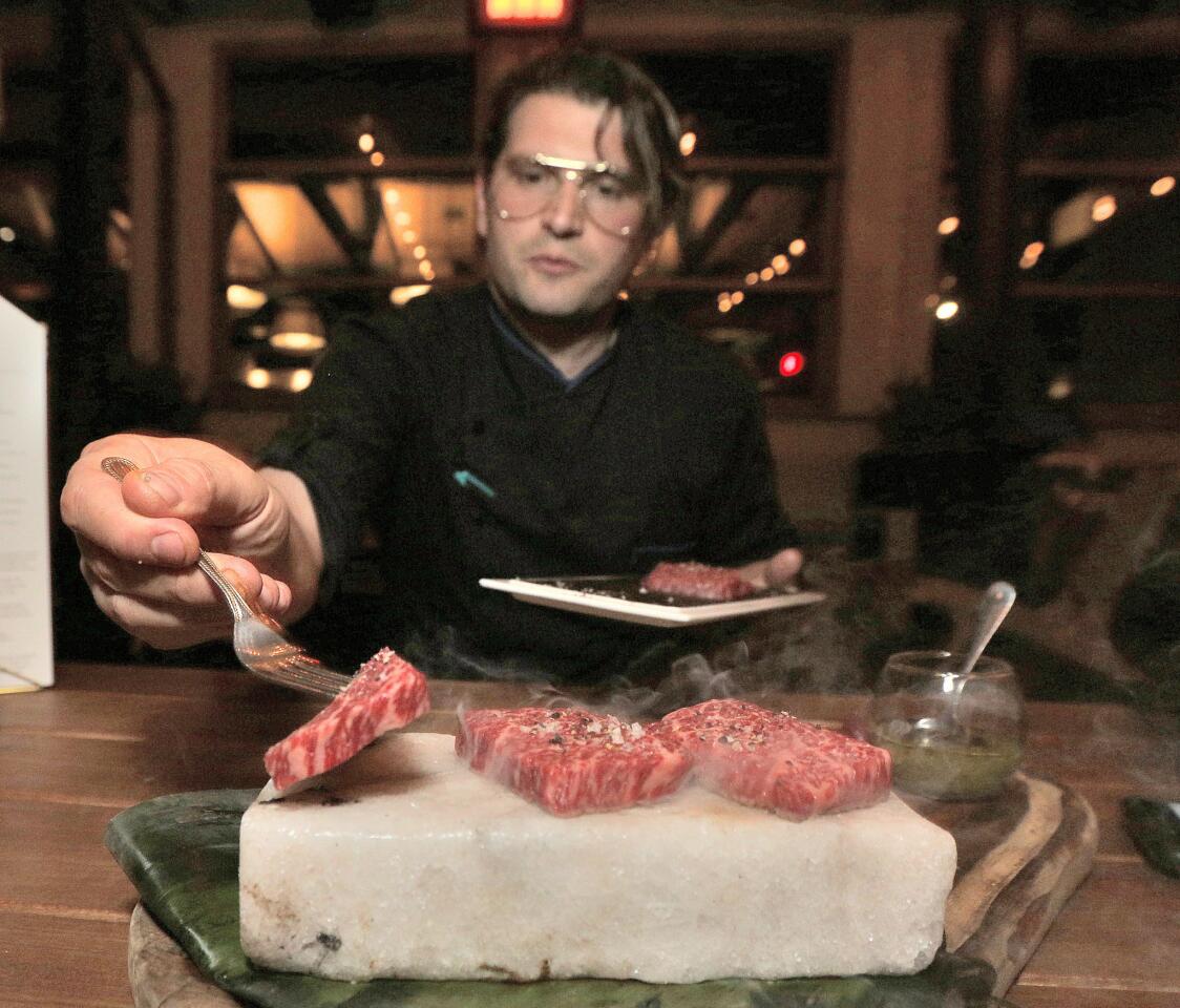 Head Chef Perry Pollack places cuts of Wagyu Carpaccio onto an 800 degree block of salt for a menu item called The Pink Brick at Castaway in Burbank in the new hidden cocktail lounge the Green Room on Thursday, November 1, 2018. The Green Room will open on November 8 for guests who make a reservation, or know about it and ask.