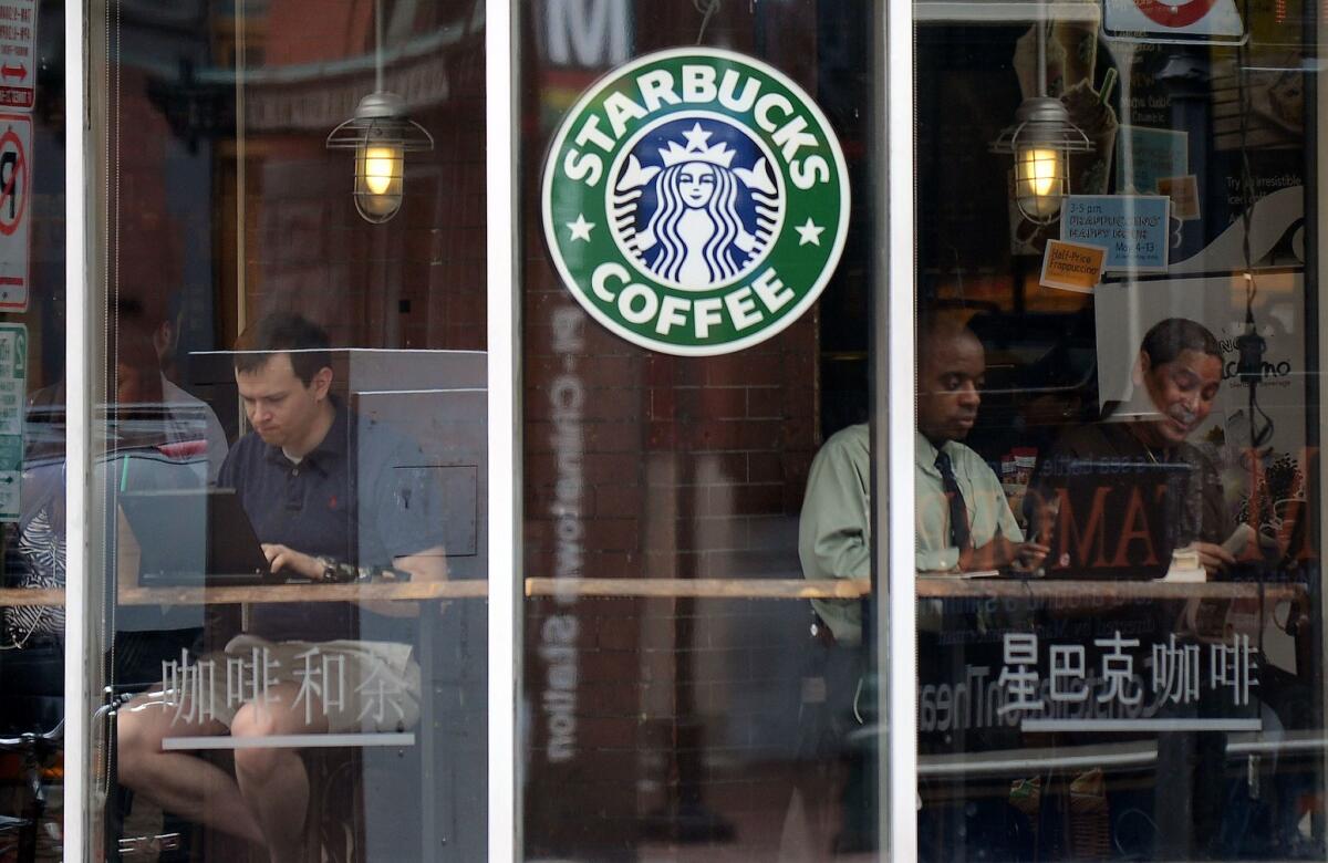 People use their laptop computers at a Starbucks in Washington in this file photo. Starbucks this week launched a campaign to encourage discussion about race relations in the United States.