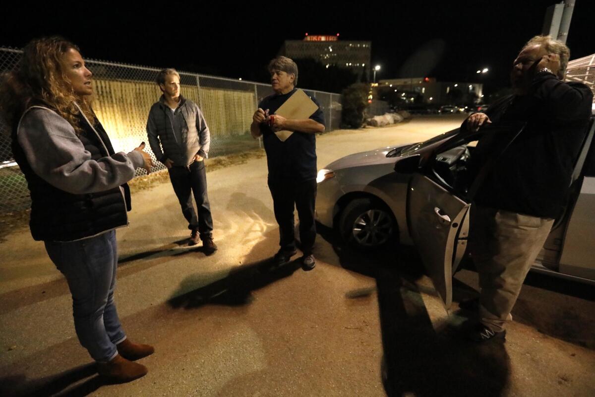 Volunteers Elizabeth Hansell, from left, her husband Jim Kennedy, Garrett Smith, on the homeless committee with the Neighborhood Council of Westchester/Playa and Scott Carni, on the Neighborhood Council of Westchester/Playa and President of the Park Advisory Board, confer while looking for homeless people in Westchester Recreation Center during the 2018 Greater Los Angeles Homeless Count.