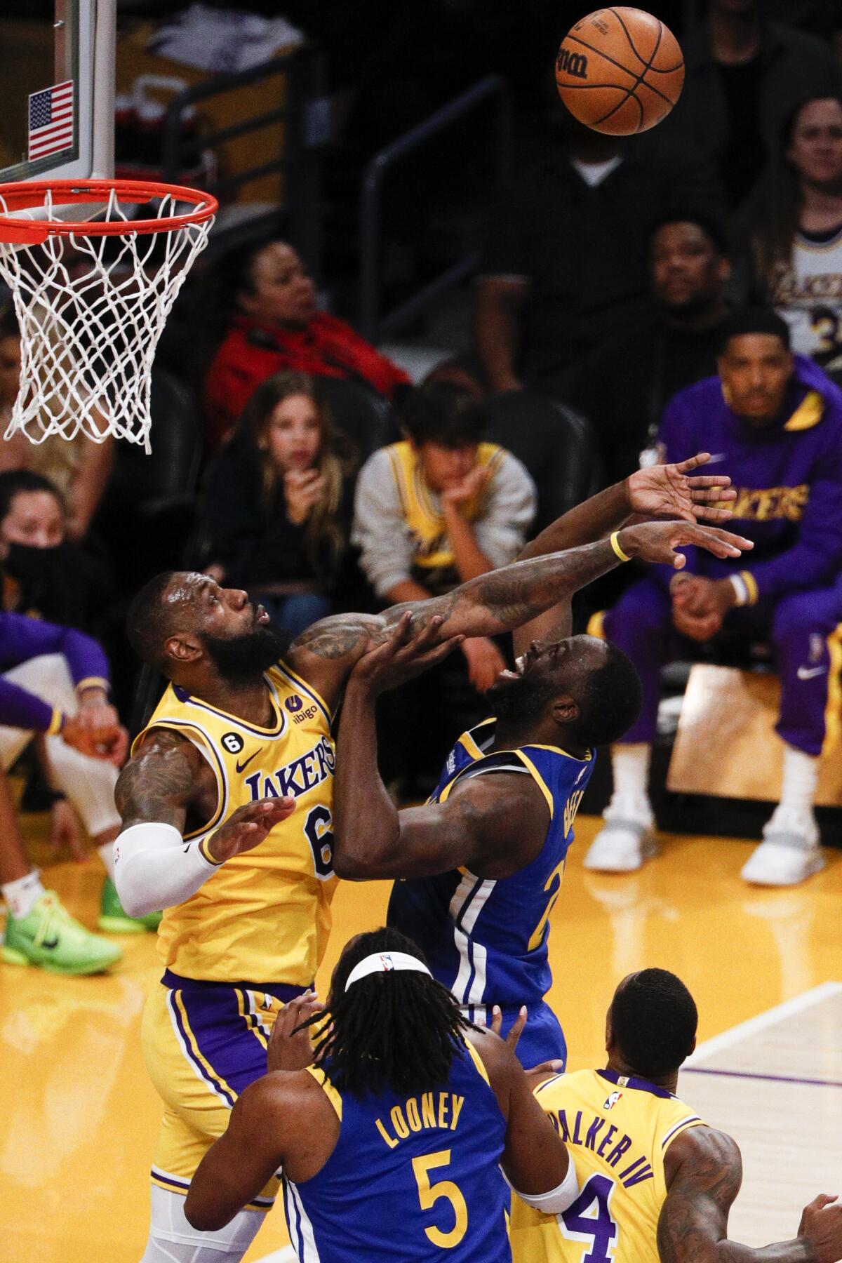 Lakers forward LeBron James jumps to block a shot by Warriors forward Draymond Green.