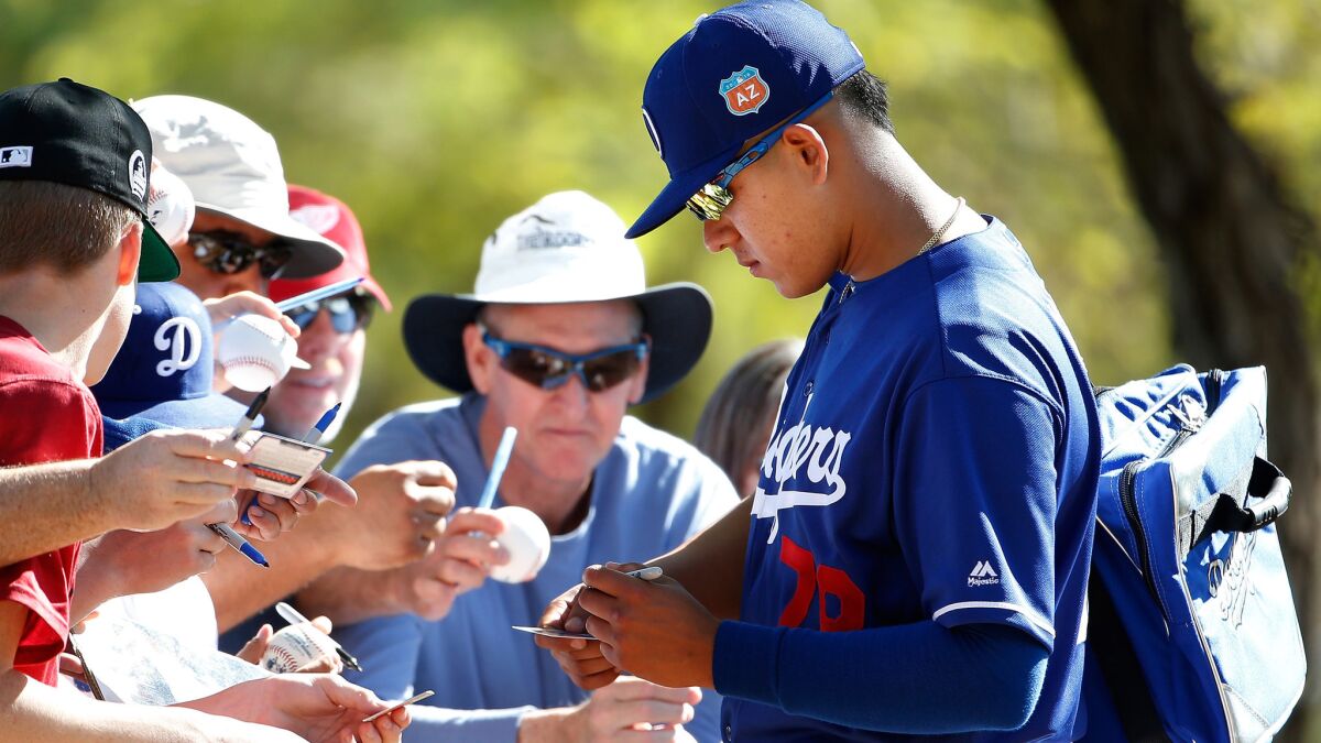 Dodgers pitching prospect Julio Urias signs autographs following a spring training workout at Camelback Ranch on Feb. 20.