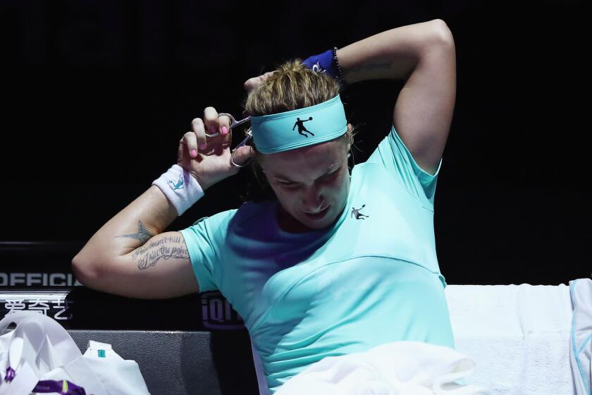 Svetlana Kuznetsova cuts her hair during a break in her singles match against Agnieszka Radwanska at the BNP Paribas WTA Finals Singapore on Oct. 24.