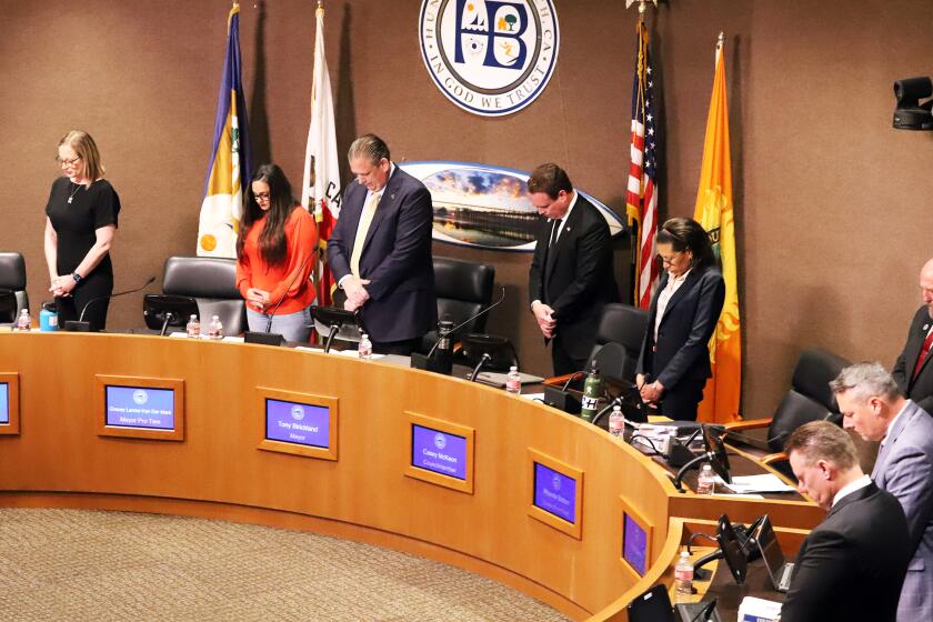 The Huntington Beach City Councilmembers bow their heads in prayer during the invocation given by the Huntington Beach Police Chaplain Bob Ewing before the city council meeting at the Huntington Beach City Council Chambers at Huntington Beach on Tuesday, May 16, 2023. (Photo by James Carbone)