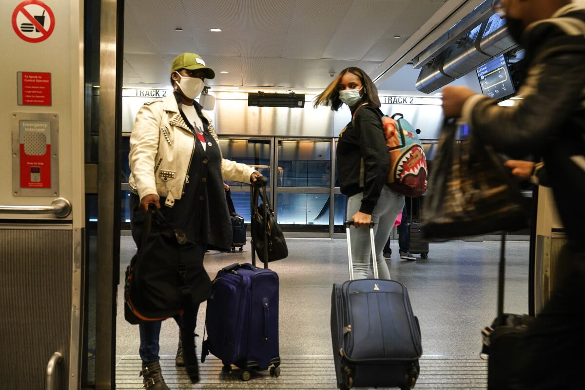 Travelers disembark from a shuttle at JFK International Airport in New York.