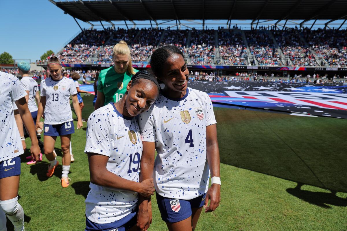 U.S. women's national team players Crystal Dunn, left, and Naomi Girma walk off the field together after a win over Wales.